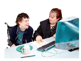 A woman is helping a man in a wheelchair to do some work at a computer