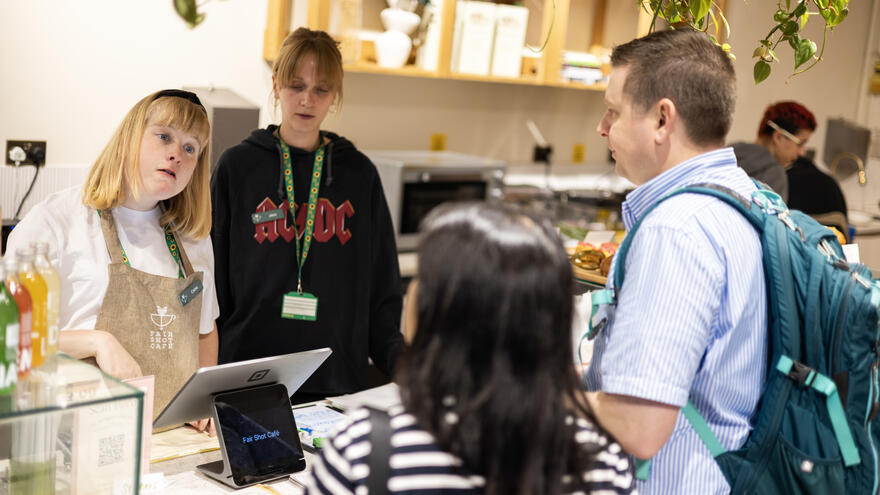 A woman serving customers in a cafe.