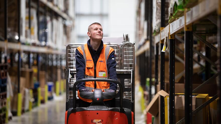 Supported Internship learner, Joel driving a low level order pick up vehicle in a warehouse where he did work experience.